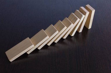 dağınık, karanlık bir masaya Domino düşüyor. Domino zar küpleri tablodaki beyaz. plakalar ışık karanlık bir arka plan ağaç, Masa