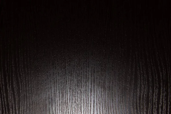 texture of dark lacquered wood with lower lighting. Texture of dark lacquered wood illuminated from below. texture light below. The texture of the tree is light from below. The texture of dark wood with a loop of light from below.