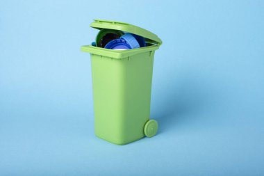 Plastik bir mavi zemin üzerine yeşil çöp atık. Plastik geri dönüşüm. Geri dönüşüm. Ekolojik kavram.