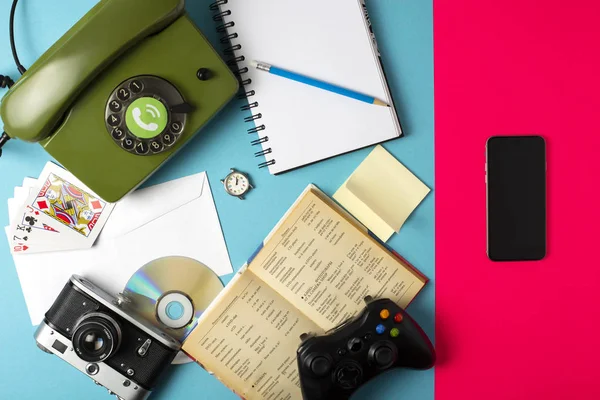 Книга, часы, камера, телефон, игра, ноутбук, CD, карандаш объединены в мобильный телефон. Концепция на цветном фоне — стоковое фото