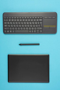 grafik tablet ve klavye mavi bir arka plan üzerinde. Metin için yer.