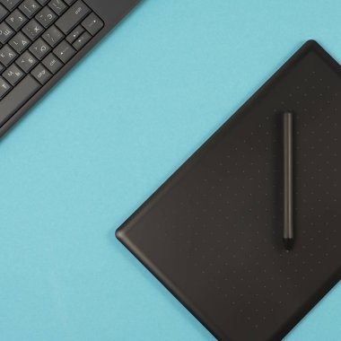 grafik tablet ve klavye mavi bir arka plan üzerinde. Metin için yer.