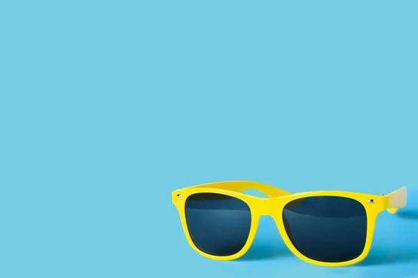 Yellow glasses isolated on a blue background — ストック写真