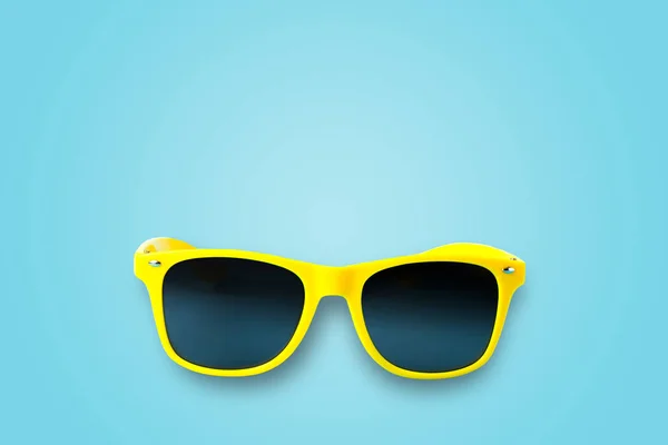 Yellow glasses isolated on a blue background — ストック写真
