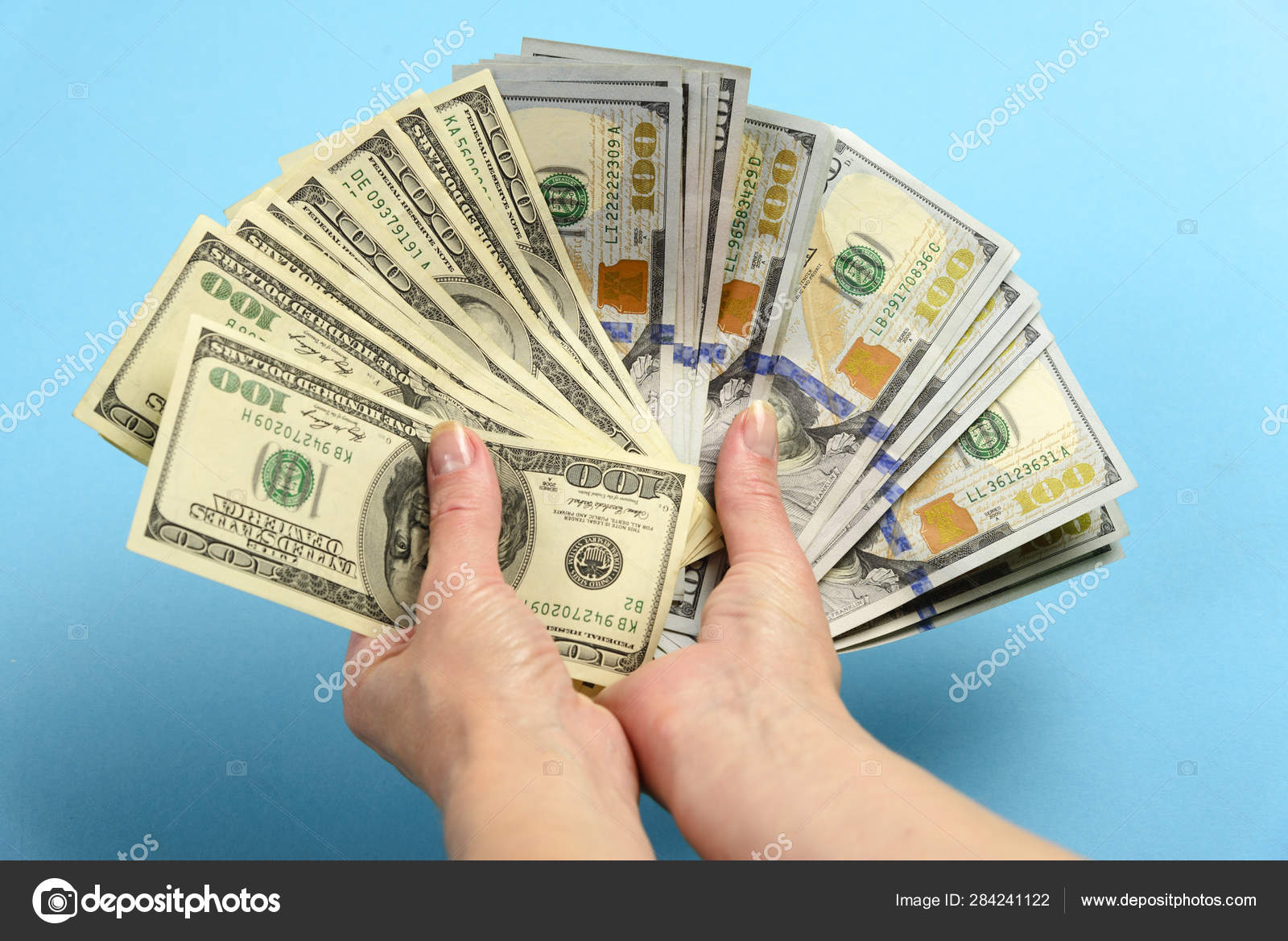 手里拿着一张100美元的钞票。手握了很多钱。从美元钞票上扇出——图库图片© dmikwiat@gmail.com #284241122