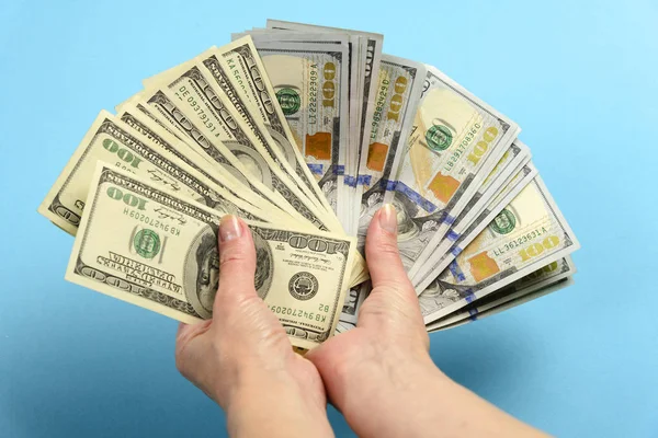 Elleri 100 dolarlık banknot tutuyor. Eller çok para tutuyor. Amerikan doları faturaları dışında Fan