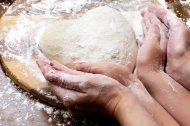 Yumurta ve sütten hamur yapmak. Kadın ve çocuk elleri ile kalp şeklinde hamur. Yemek pişirme ve ev konsepti