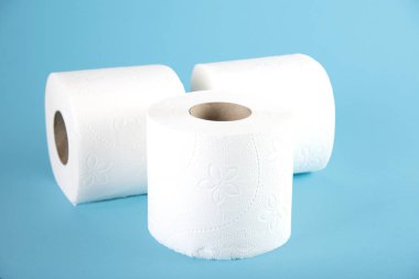 Renkli bir arka planda beyaz tuvalet kağıdı üç rulo