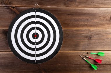 Dart hedef ahşap bir arka plan ve üç renkli dart izole. Hedefi vur