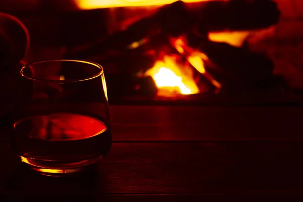 Glass of alcoholic drink wine in front of warm fireplace. Magical relaxed cozy atmosphere near fire — Stock Photo, Image