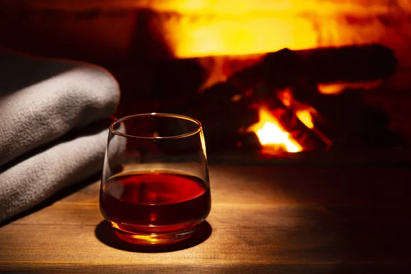 Glass of alcoholic drink wine in front of warm fireplace. Magical relaxed cozy atmosphere near fire — Stock Photo, Image