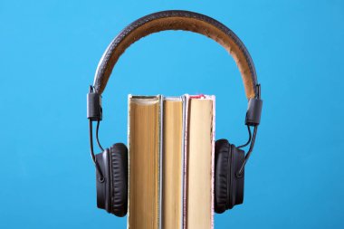 kulaklık ve kitap ama mavi arka plan karşı, sesli kitap kavramı, bir kitap dinleme