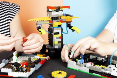 Lego robotu. Bir çocuk ve bir kadın plastik parçalardan bir robot monte, tren. En ateşli aletler. E-öğrenme. Modern eğitim teknolojileri. Eğitim