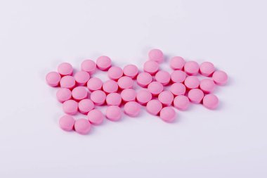 Beyaz arka planda pembe yuvarlak haplar. Yukarıdan görüntüle