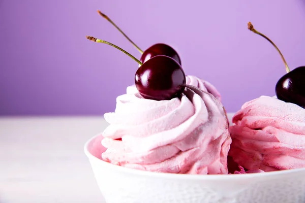 stock image Lots of sweet pink cherry cakes in a white plate on a wooden background. Pink cherry marshmallows. Red cherry