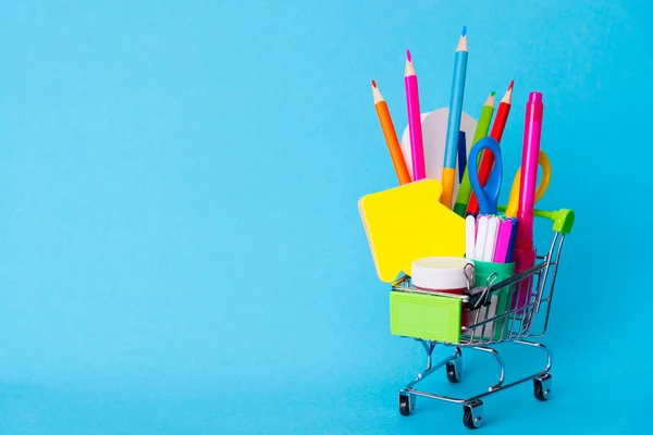 Heldere Briefpapier Voorwerpen Een Mini Supermarkt Trolley Een Blauwe Achtergrond — Stockfoto