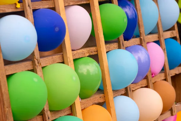 Ballons multicolores dans des cellules en bois. Fond de ballons de couleur — Photo