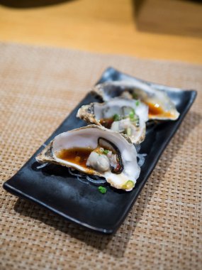 Siyah plaka üzerinde taze istiridye açıldı