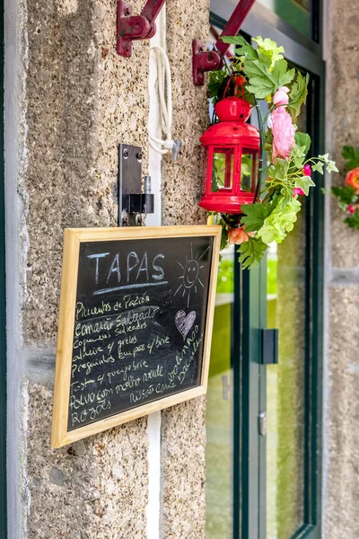 Tapas at the historical center of Guimaraes, Braga, Portugal. This center is listed on the Unesco World Heritage map. Sign and menu with red lantern.