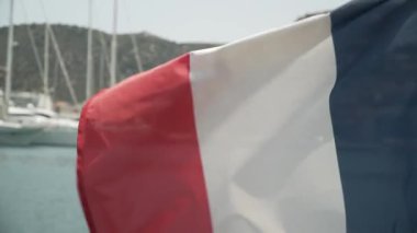 Fransa bayrağı deniz ve demirli yatlar fon karşı rüzgarda gelişir