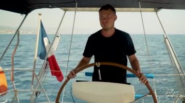 Bir yat başında boyunduruğu olan ve onu kontrol eden bir adam.