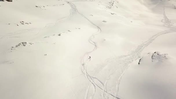 Snowboarder descendant d'une montagne enneigée, prise de vue aérienne, Elbrus — Video