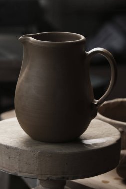 Bir çömlekçi elinde bir ham toprak kap. Atölyesinde Seramik Atölyesi