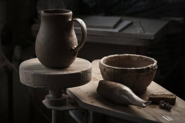 Bir çömlekçi elinde bir ham toprak kap. Atölyesinde Seramik Atölyesi