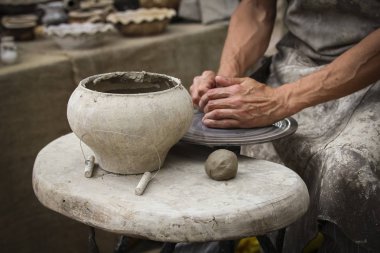 Bir çömlekçi elinde bir ham toprak kap. Atölyesinde Seramik Atölyesi