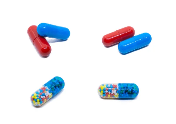 Χάπια απομονωμένα σε λευκό. Κόκκινα και μπλε χάπια. Διαφανές δισκίο με χρωματιστά σωματίδια. — Φωτογραφία Αρχείου