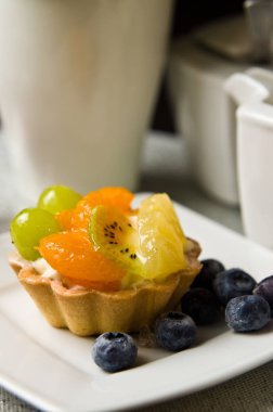 Kahve tablo olan bir lezzetli meyve pasta natürmort kompozisyon.