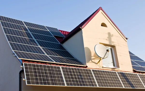 グリーン エネルギー 赤いトタン屋根の上の太陽電池パネルの現代源 — ストック写真