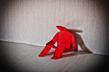 Yalnız bir adamın kağıt kesme bir duvara yapılmış soyut resim.