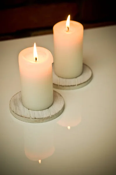 Deux bougies allumées sur un placard blanc . — Photo