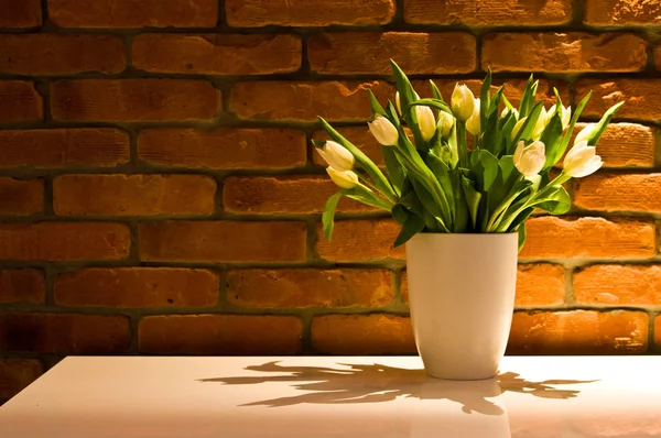 Букет жовтих тюльпанів на стіні з червоної цегли — стокове фото