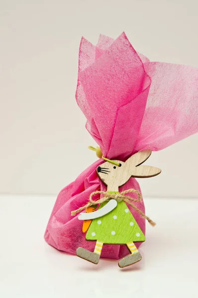 Húsvéti ajándék koncepcióval, fa nyuszi játék rózsaszín szövet wrap — Stock Fotó
