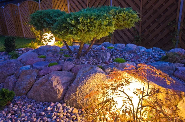 Home garden at night, illuminated by globe shaped lights