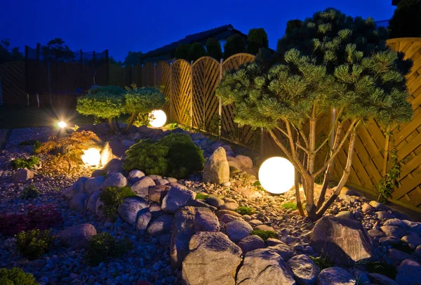 夜晚的家庭花园，由地球形的灯光照亮 — 图库照片