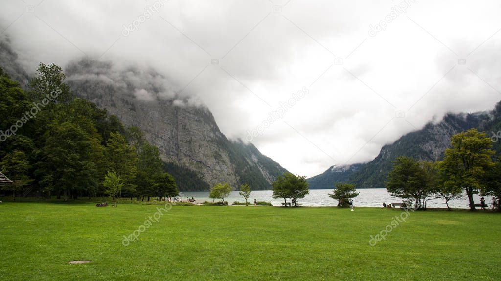clouds covering mountain top lake