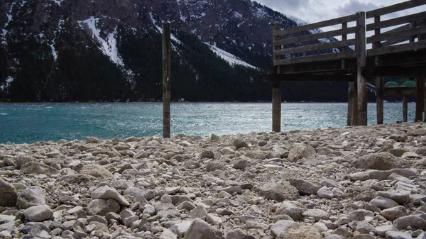 Cascalho à beira do lago e barco etapa de desembarque lago alpino — Fotografia de Stock