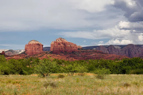 meadow forest and red rock mountain