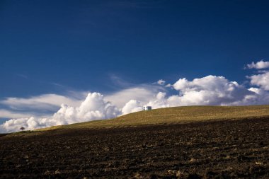 tepenin arkasında beyaz bulutlar ile mavi gökyüzü