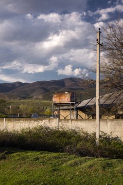 gürcistan eski çürük evlerin önünde eski paslı su tankı