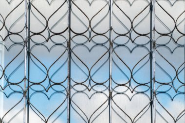 Korunmak için pencerede dekoratif metal örgü var. Pencere camı ızgara desenini yansıtır