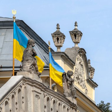 Ukrayna, Lviv 'deki Aziz George Katolik Katedrali cephesinin ayrıntıları. Güneşli bir yaz gününde Ukrayna ulusal bayraklarıyla süslenmiş barok heykeller ve pervazlarla giriş.