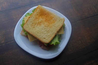 Pastırma, peynir ve taze sebze ile sandviç. Sahanda yumurta, sosis ve peynir ile bir sandviç hazırlama.