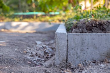Döşeme tabanı, yabani otların büyümesini engelleyen ve toprak ile molozların karışmasını önleyen bir zar kullanılarak hazırlanıyor. Seçici odak.