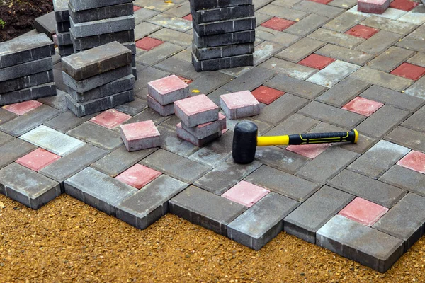 Avlu avlusunda beton döşeme döşeme döşemesi. Profesyonel işçiler düz kumlu bir temele garaj yolu, kaldırım ya da veranda için yeni fayanslar ya da levhalar kuruyorlar. Seçici odak.