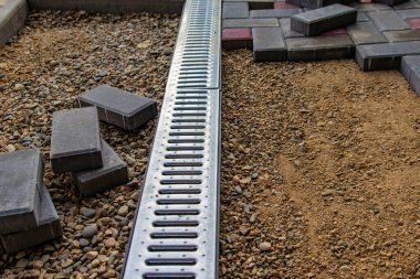 Profesyonel tuğla ustaları yol, kaldırım ya da veranda için yeni kiremitler ya da levhalar döşüyorlar. Evin avlusuna gri beton döşeme döşemesi.