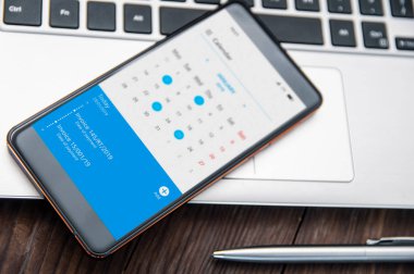 Smartphone cadı çentik masada hakkında faturaları ödemek için hatırlatmak takvim uygulaması ile yatıyor. Ekranda grafik programında oluşturduğunuz uygulama